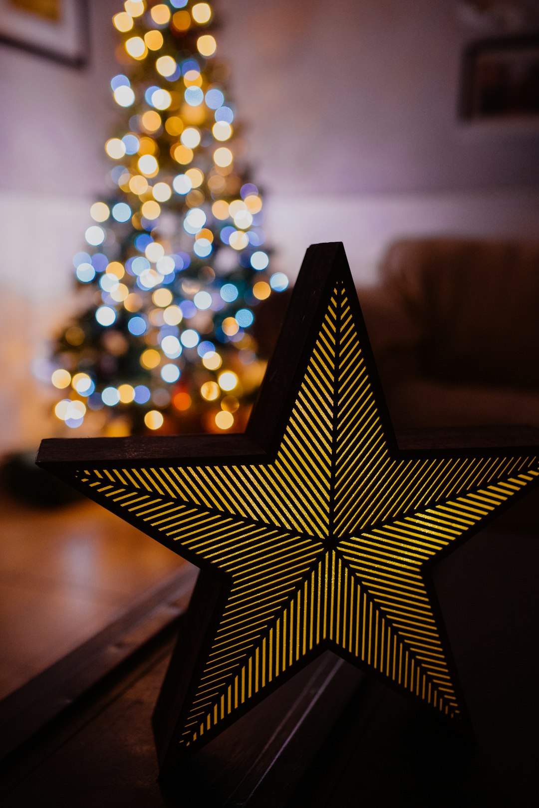 gold and black star near lit Christmas tree
