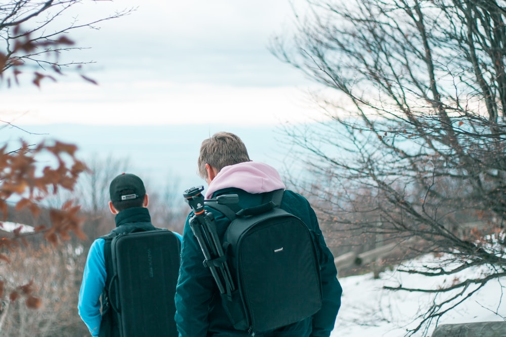 two men walking on snowfield at daytime