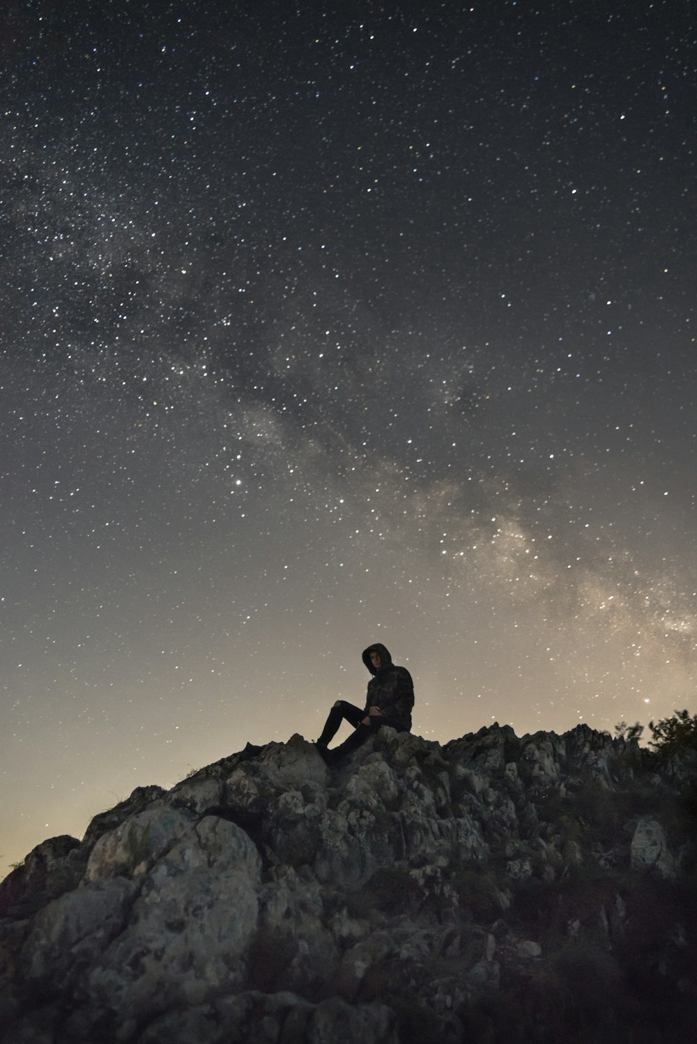 person sitting on white mountain rock