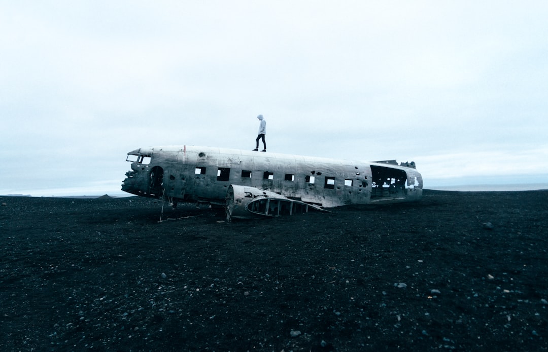 person standing on plane crash under nimbus clouds