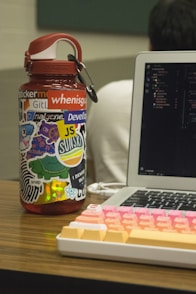 orange plastic container beside turned-on MacBook Pro