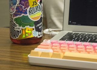 orange plastic container beside turned-on MacBook Pro