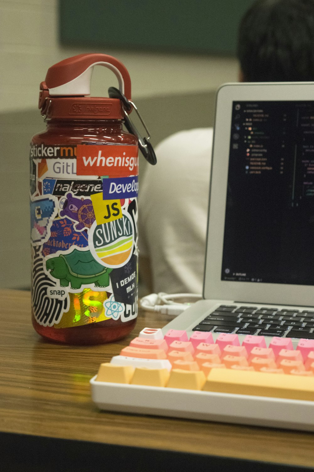 orange plastic container beside turned-on MacBook Pro