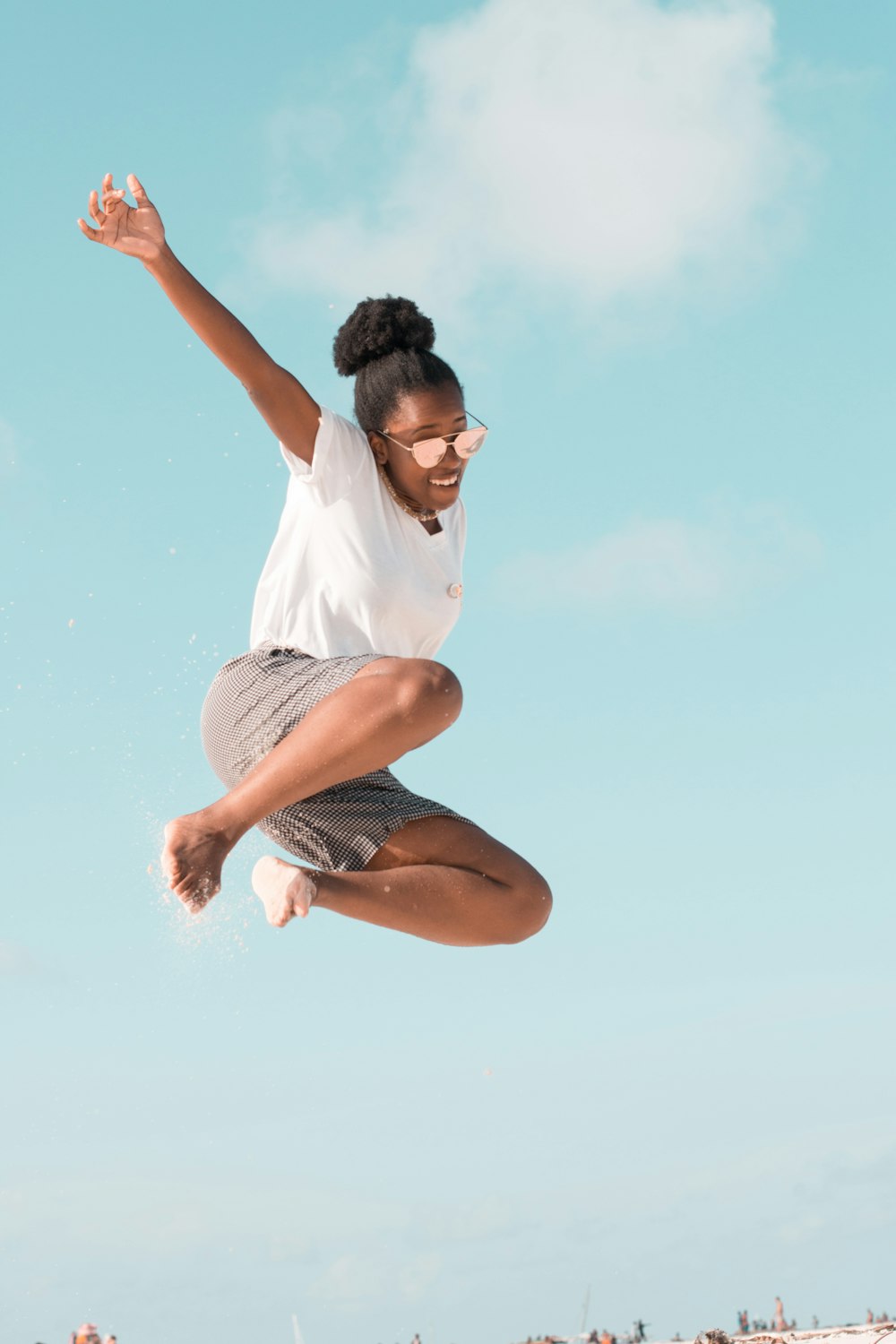 woman jumping wearing white shirt during daytime