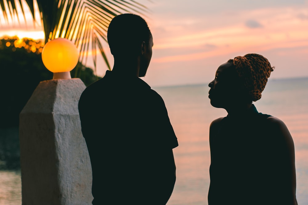 couple standing beside body of water