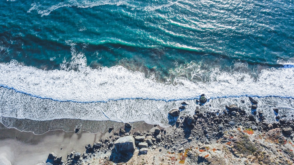 rock and sand shore during day