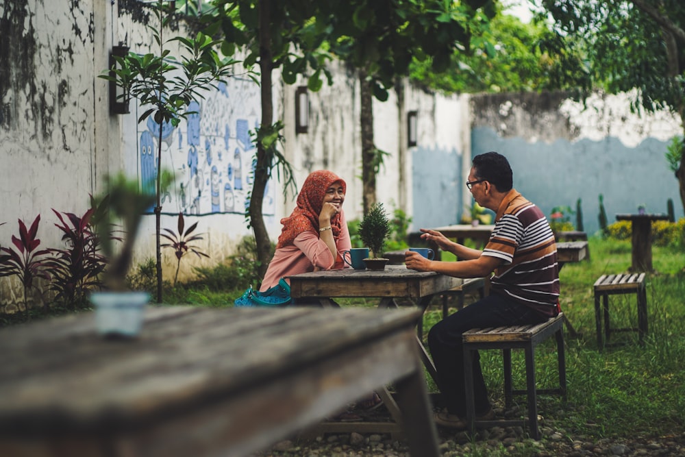 man and woman sitting beside table