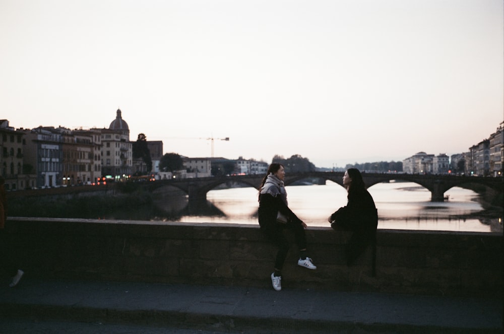 two person sitting on bridge