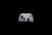 A white gaming controller with black buttons and joysticks is centered against a solid black background. The controller features various buttons, including the Xbox logo, directional pad, and colored action buttons labeled A, B, X, Y.