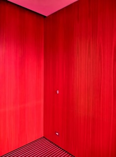 Close-up of a vibrant red wall freshly painted with smooth finish in a cozy living room.