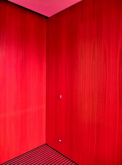 Close-up of a vibrant red wall freshly painted with smooth finish in a cozy living room.