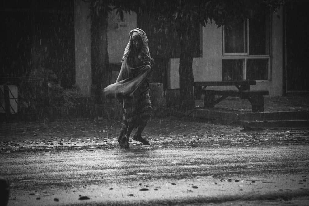 woman walking outside the house while raining