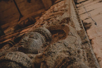 A softly glowing ancient Harappan seal resting on a dark sandstone surface with subtle golden highlights.