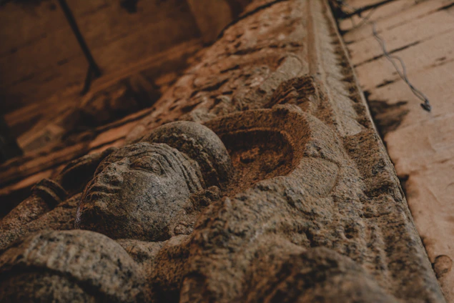 A softly glowing ancient Harappan seal resting on a dark sandstone surface with subtle golden highlights.