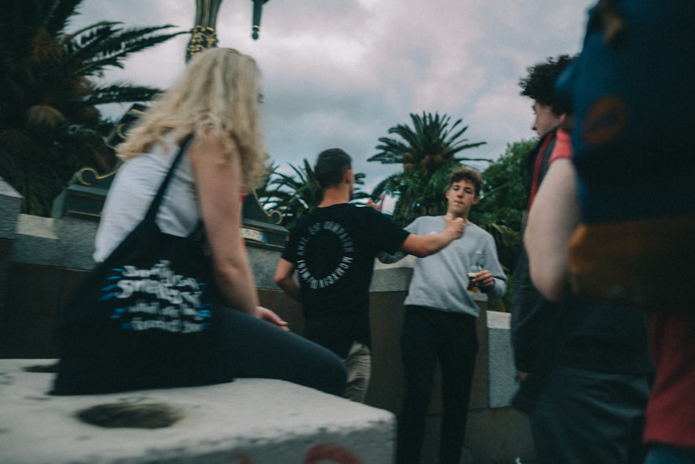 woman witting on concrete facing men