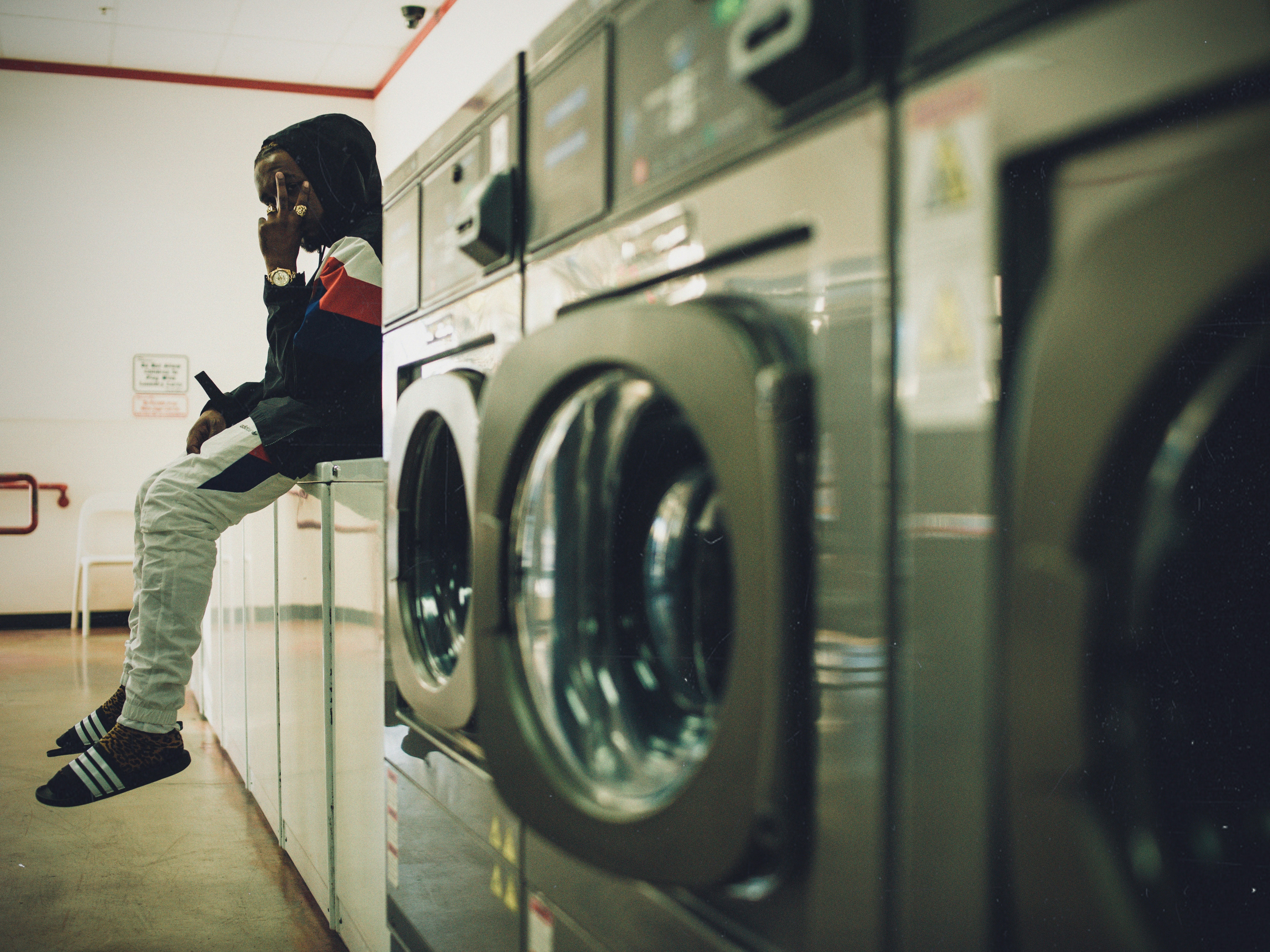 man sitting on laundry appliances