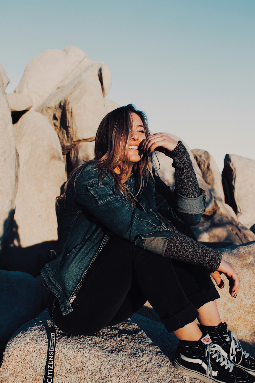 sitting and smiling woman wearing black pants