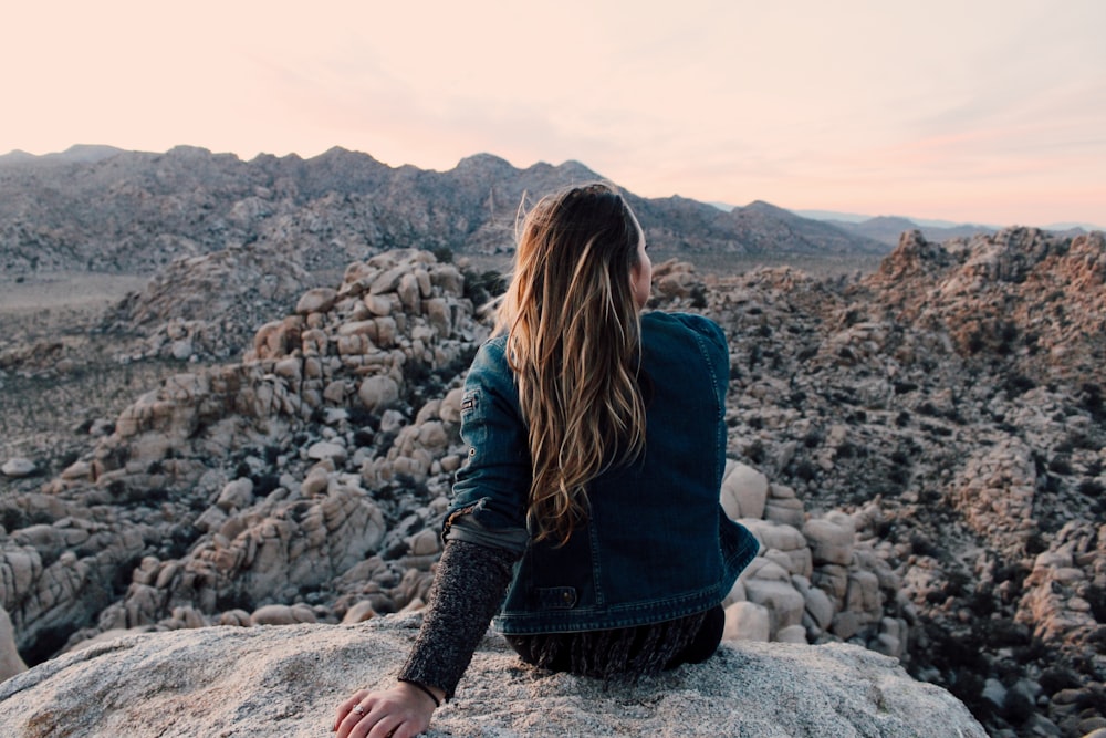 woman sitting on rock