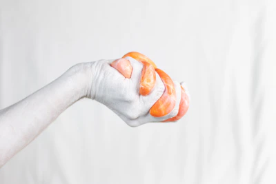 Close-up of hands gently squeezing a soft, fruit-shaped squishy toy.