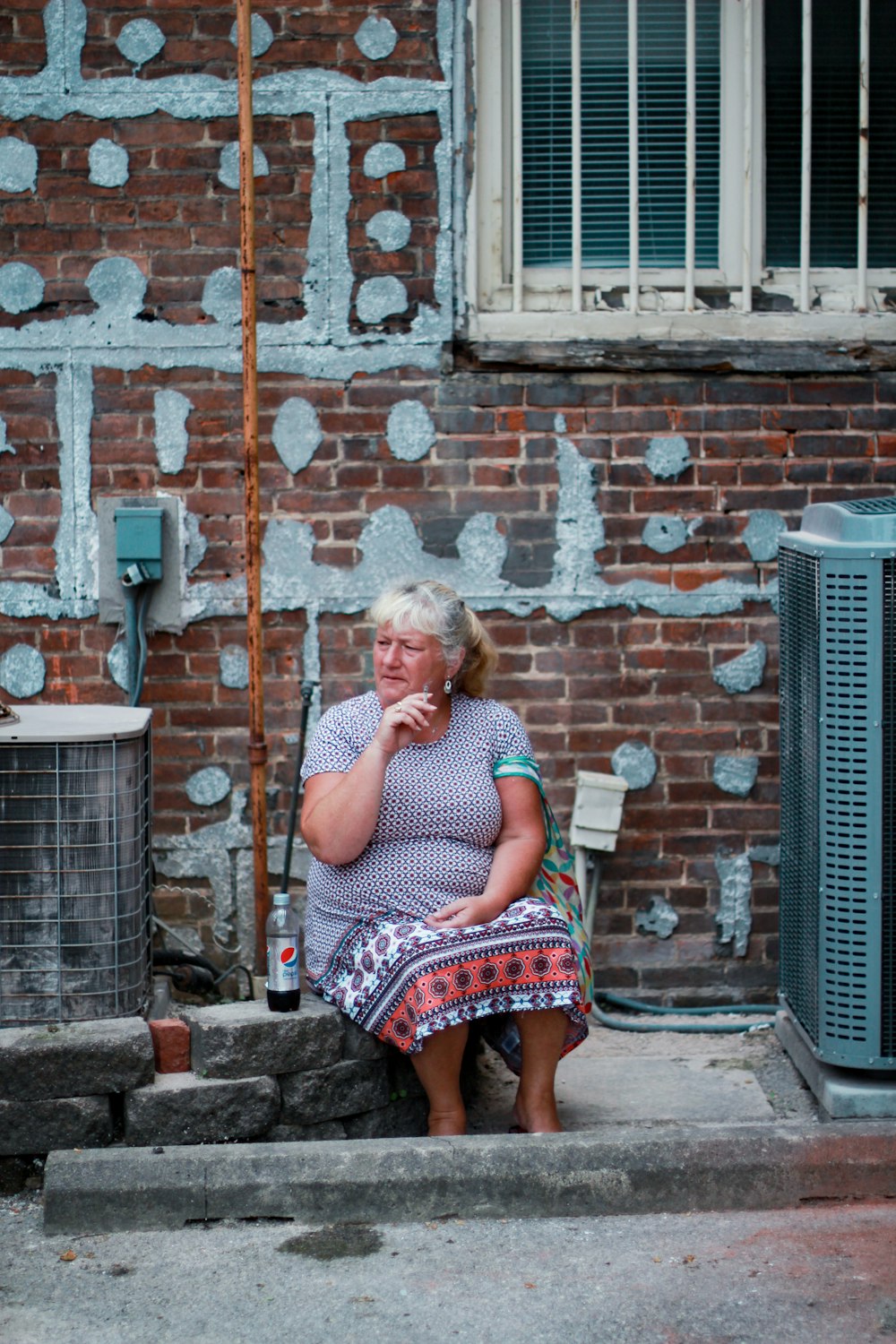 woman sitting on concrete brick curb