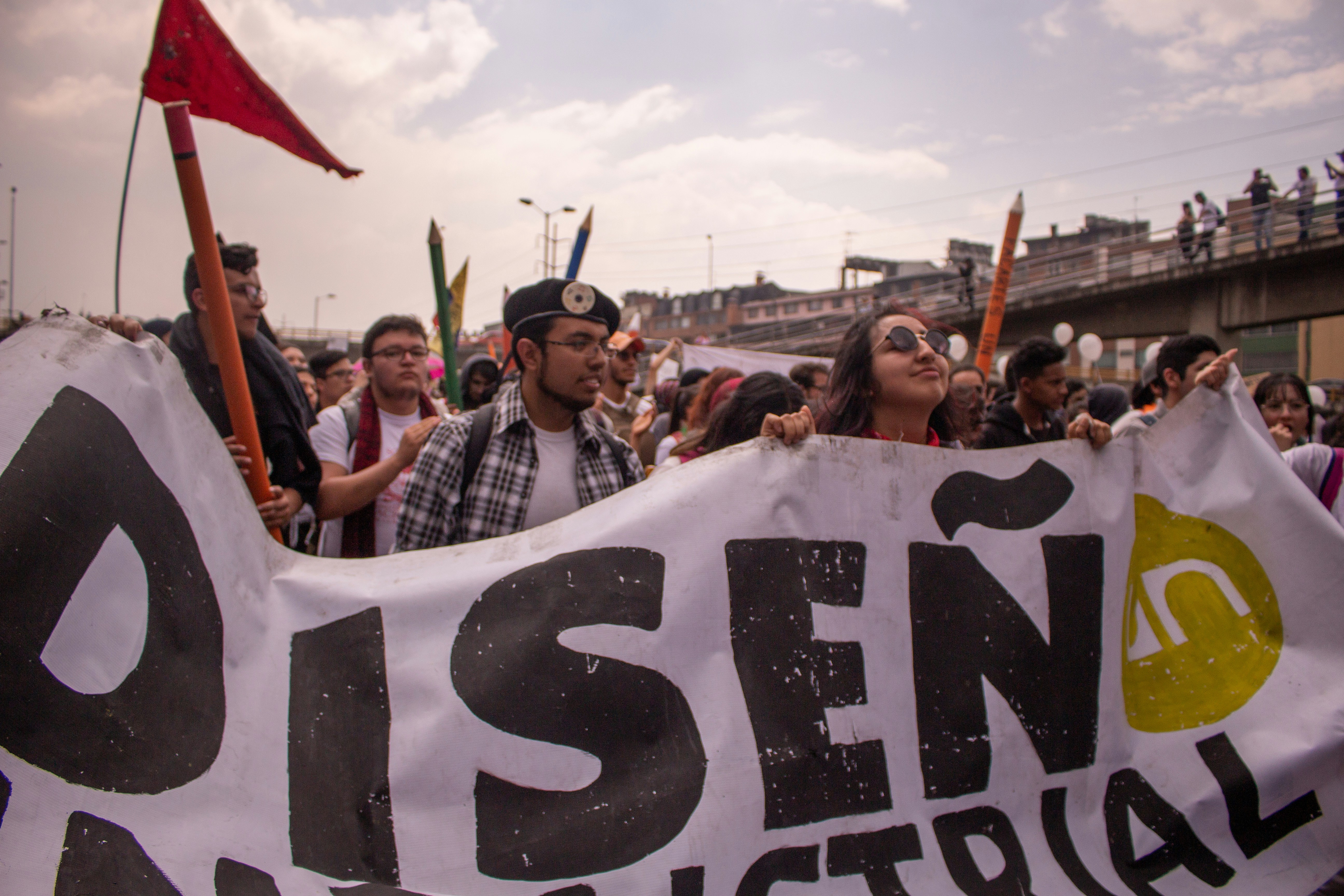 group of people holding Disen text tarpaulin