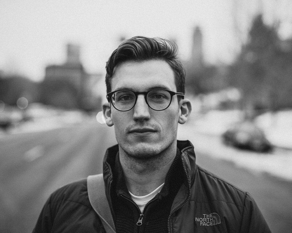 grayscale photo of man in The North Face jacket