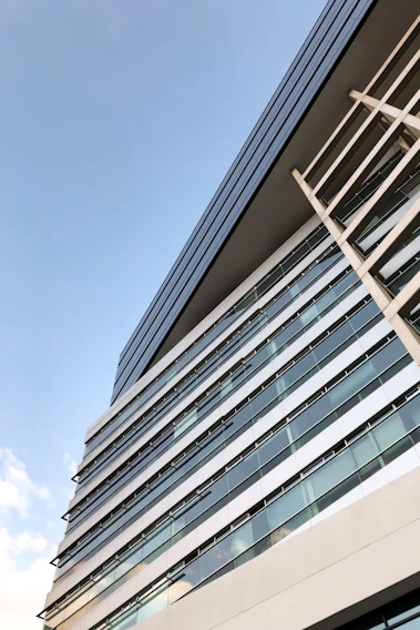 A sleek modern building under construction with clean lines and a clear sky background.