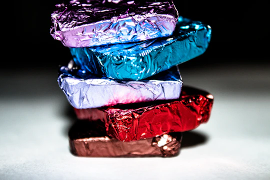 A close-up of colorful chocolate boxes with elegant designs stacked neatly.