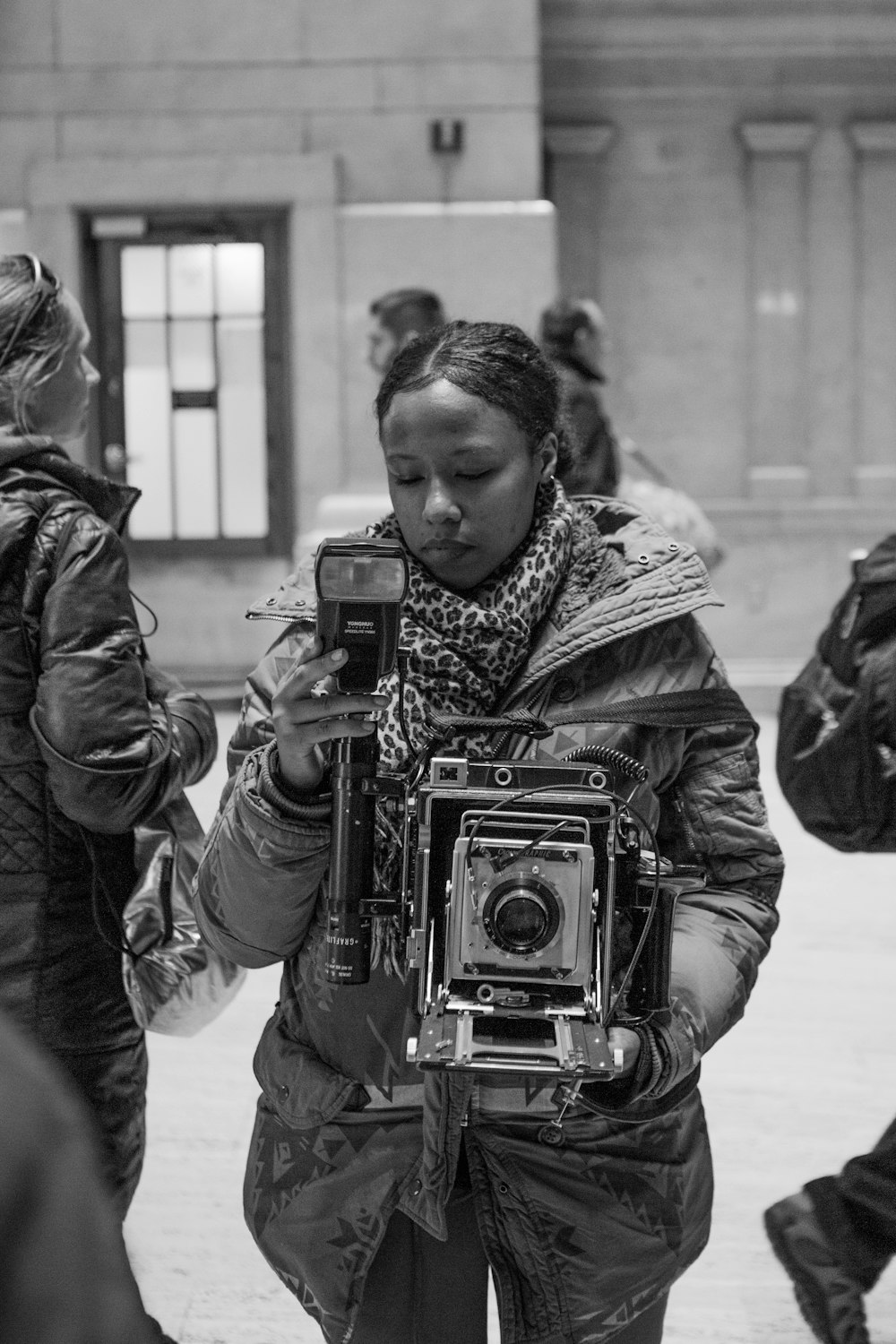 grayscale photo of woman holding camera