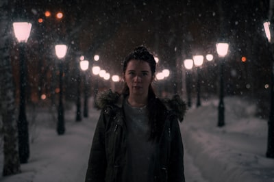 selective focus photography of woman standing on snowfield blizzard teams background