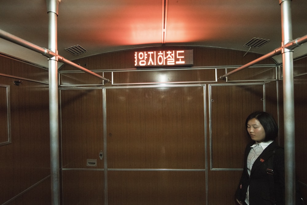 woman standing near the brown wooden wall