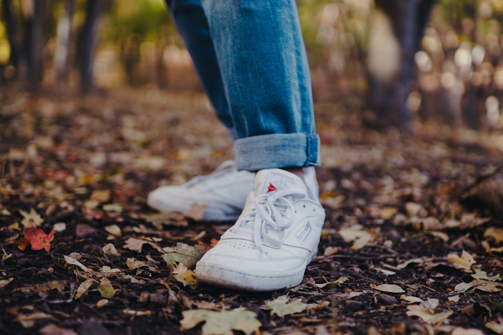 Persona en jean azul y zapatilla blanca