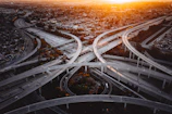 A panoramic view of a modern highway interchange under construction at sunset.