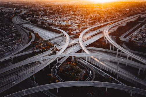 A panoramic view of a modern highway interchange under construction at sunset.