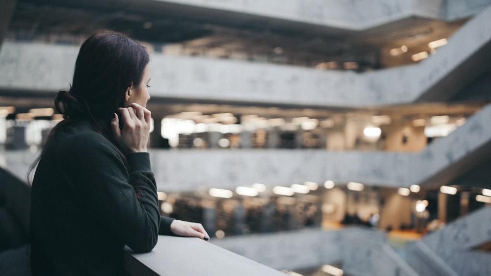 selective focus photography of woman standing beside wall