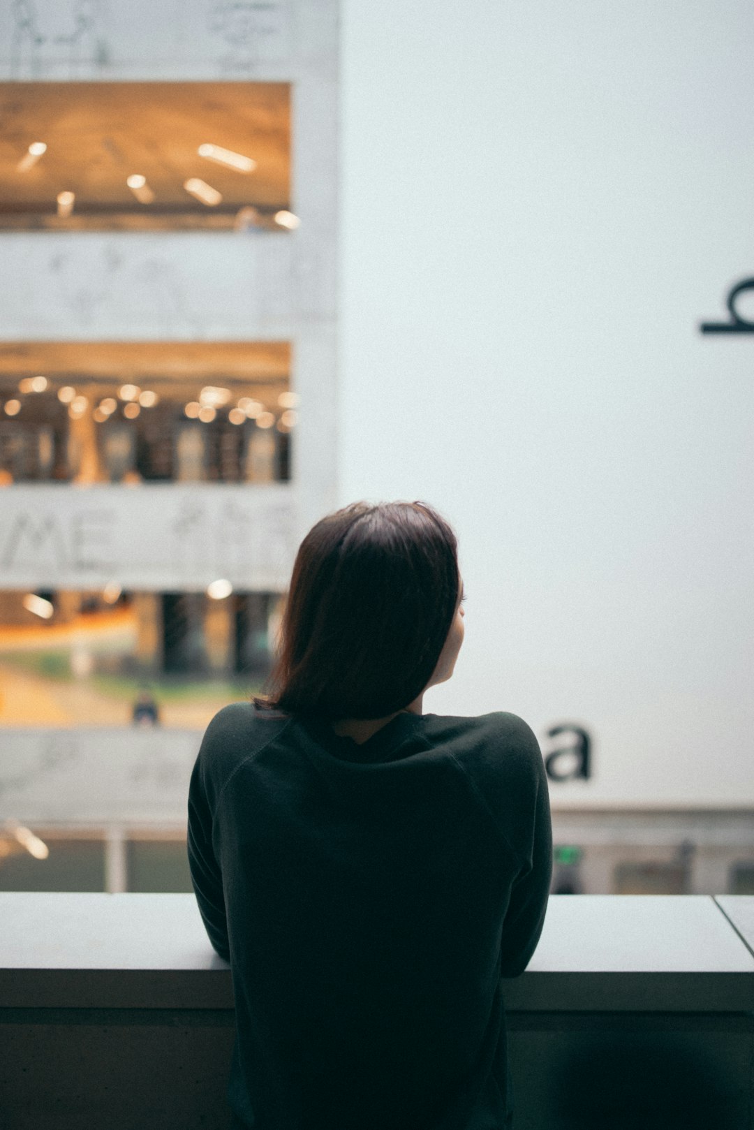 selective focus photography of woman standing beside wall