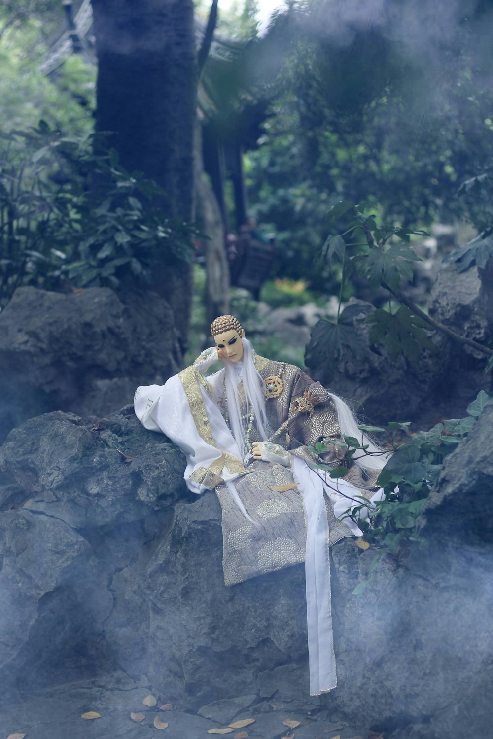 man wearing grey dress sitting on stone