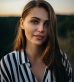 smiling woman wearing white and black pinstriped collared top