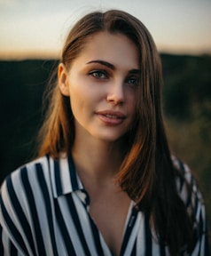 smiling woman wearing white and black pinstriped collared top