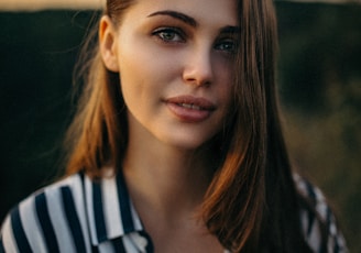 smiling woman wearing white and black pinstriped collared top