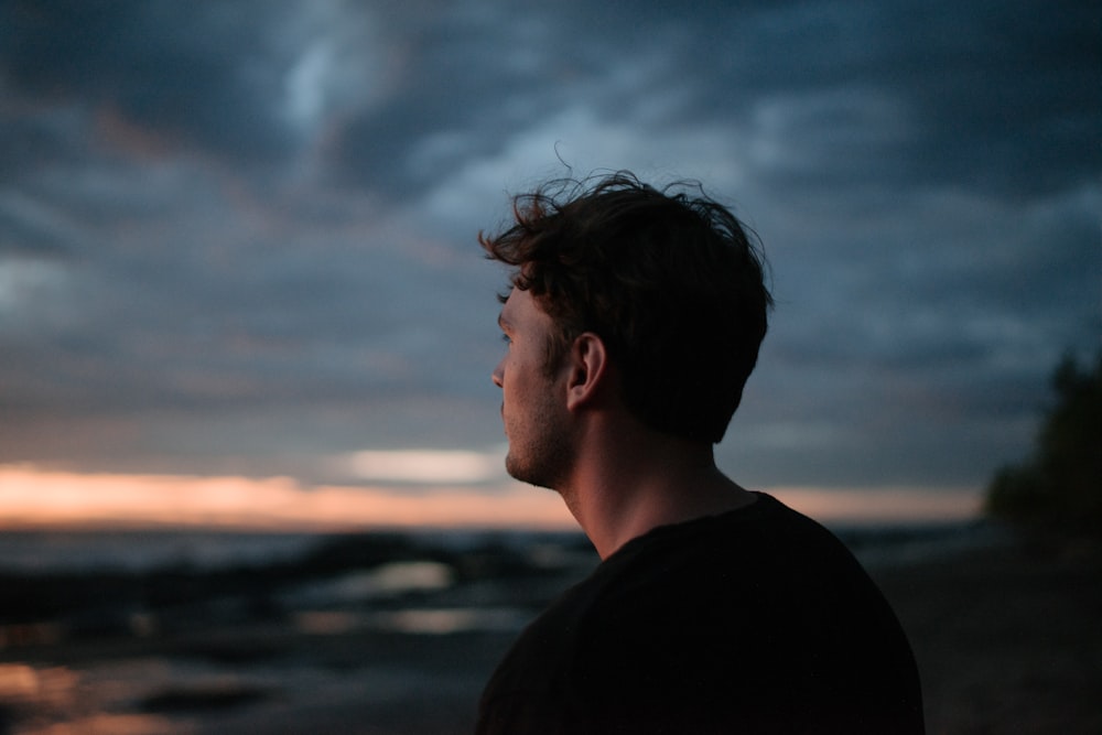 selective focus photography of man under cloudy sky