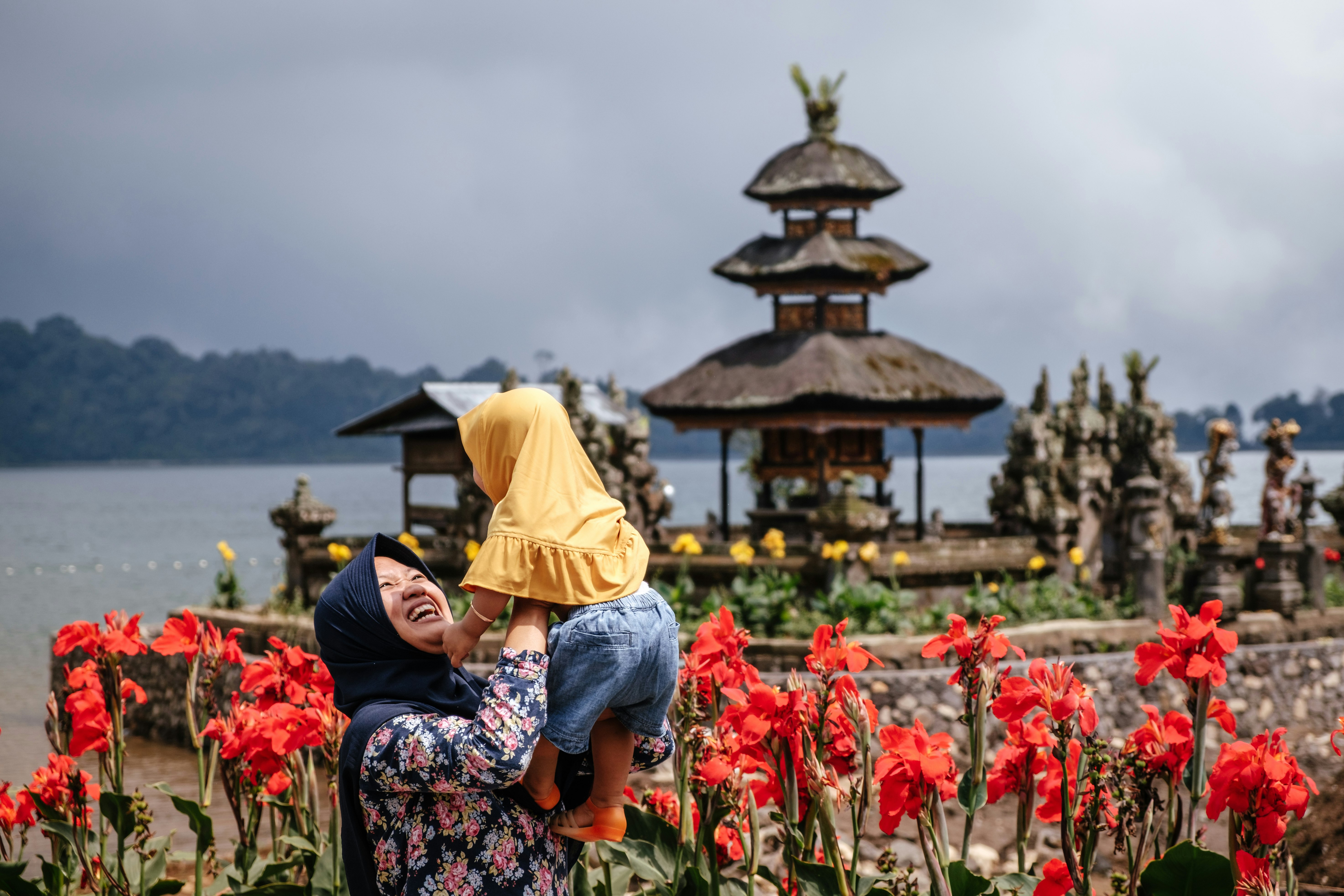 woman wearing black hijab carrying toddler