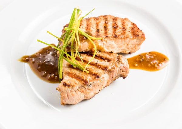 Meat with sauce on white plate
