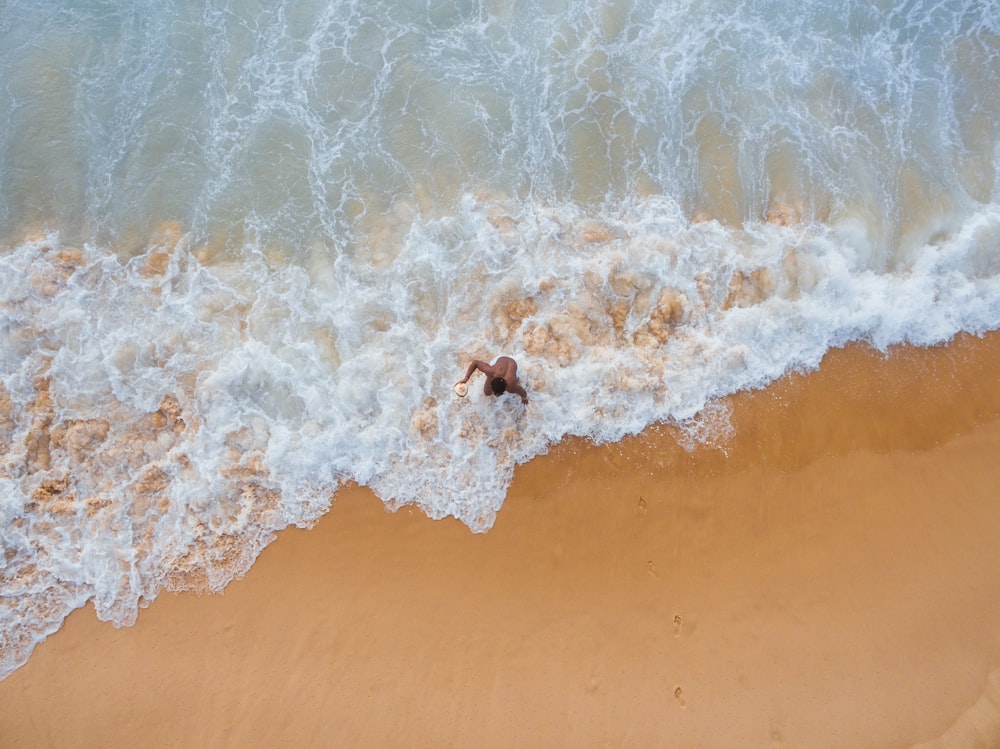 aerial photography of man on seashore