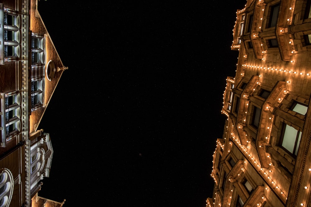 low-angle photography of buildings with turned on light strings