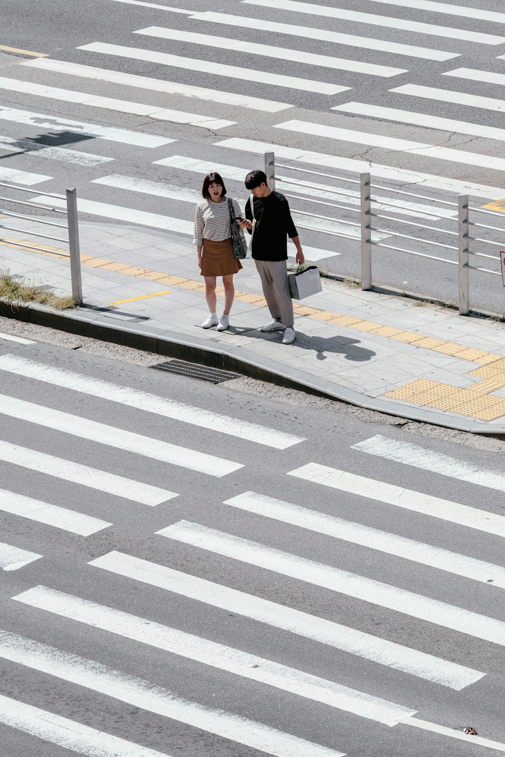 man and woman standing on sidewalk