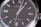 Close-up view of a luxury wristwatch featuring a sleek black dial with silver hour markers and hands, encased in a polished stainless steel. The branding and model information are visible on the dial, emphasizing elegance and precision.