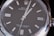 Close-up view of a luxury wristwatch featuring a sleek black dial with silver hour markers and hands, encased in a polished stainless steel. The branding and model information are visible on the dial, emphasizing elegance and precision.