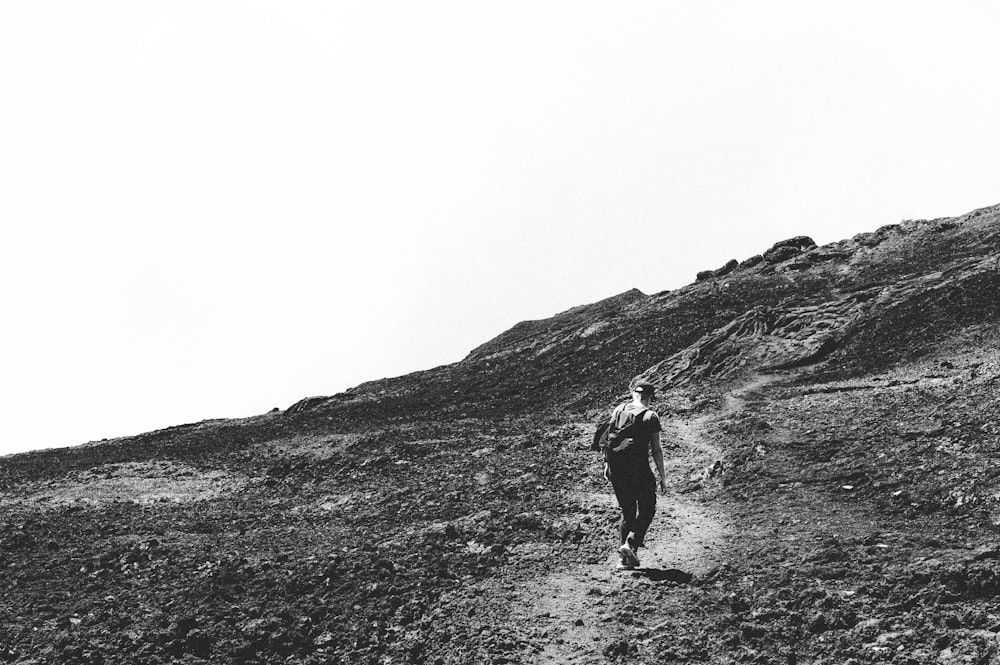 grayscale photography of person hiking during daytime