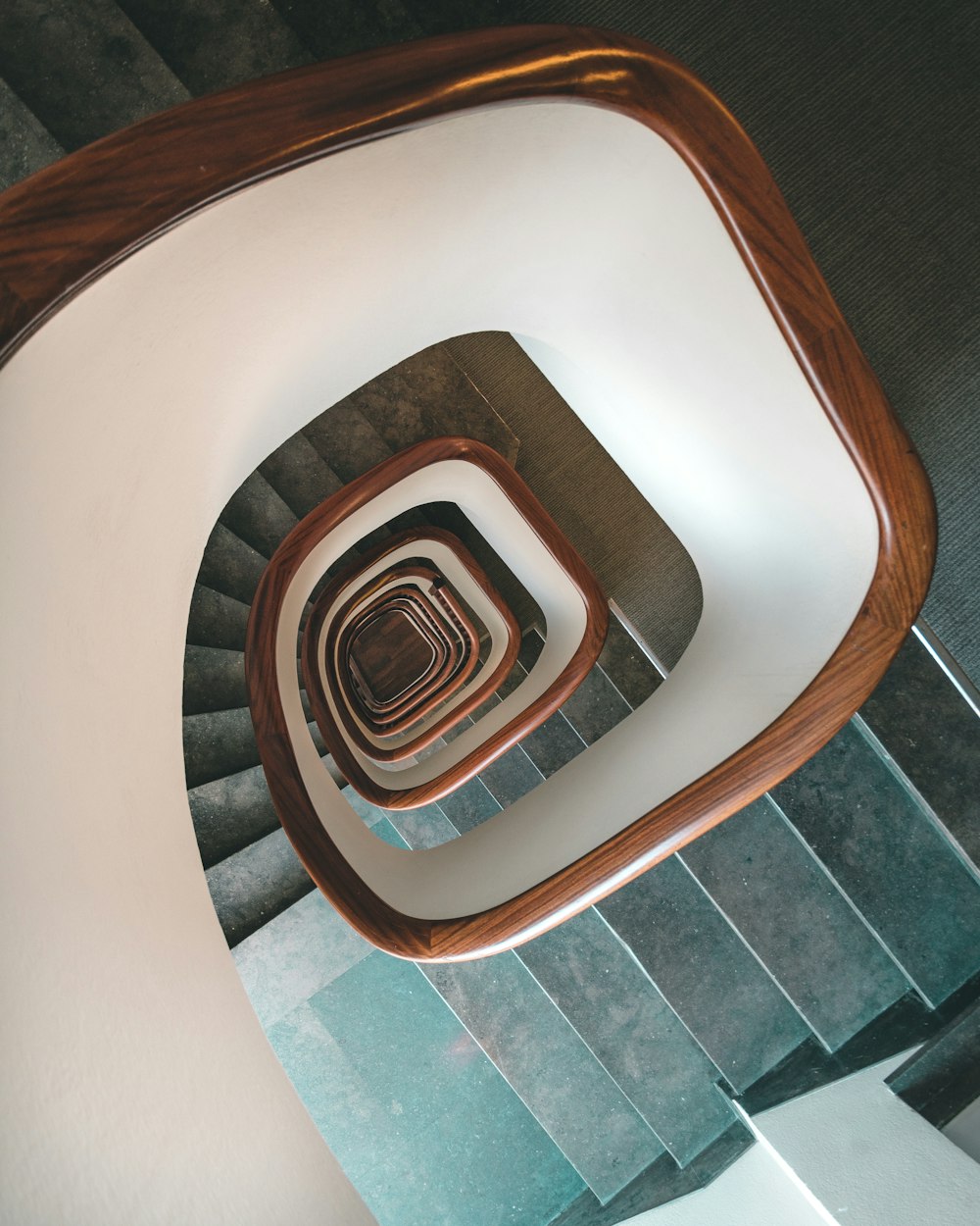 white spiral staircase with brown wooden railings